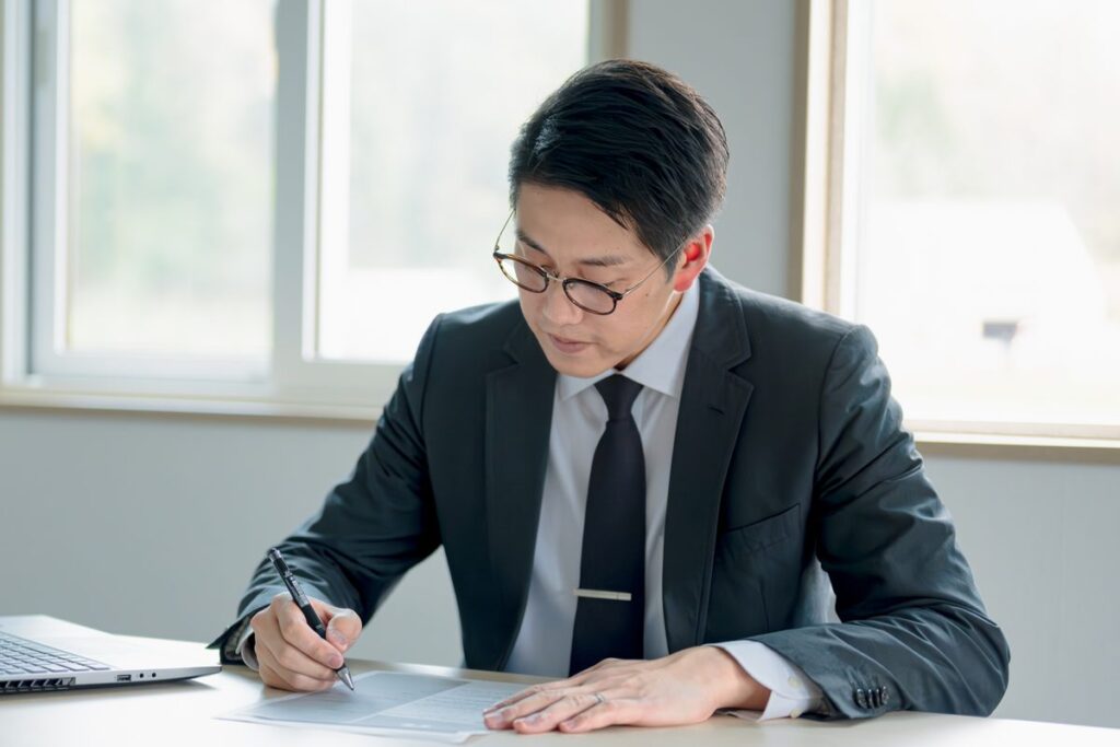 書類を確認して署名する会社員