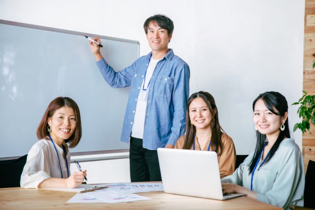 ホワイトボードの前で導入計画を打ち合わせするチーム