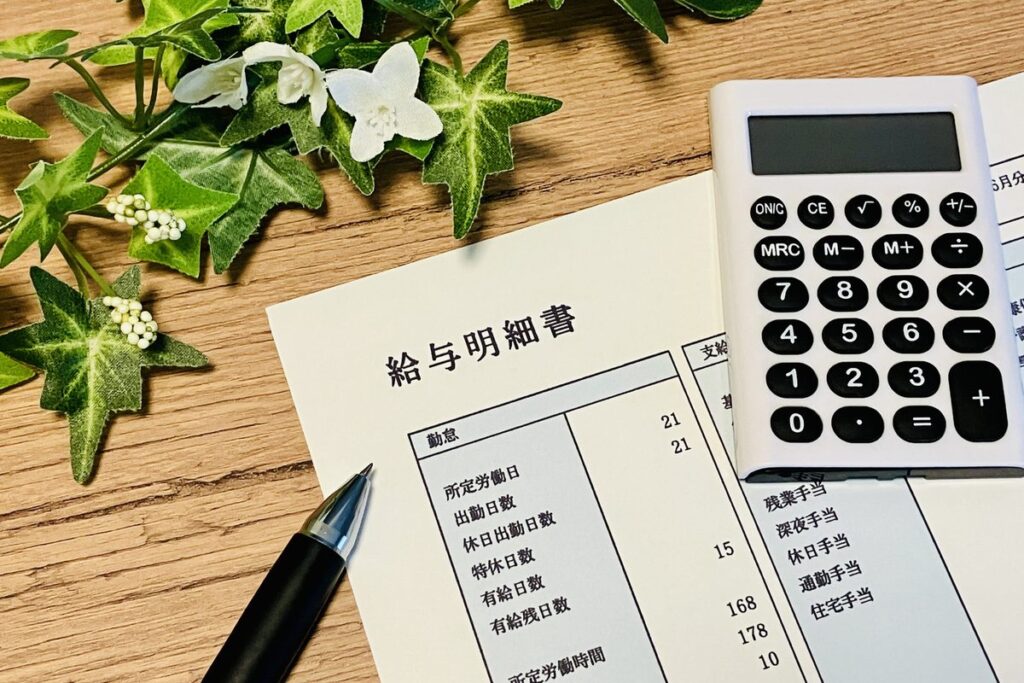 給与明細書と電卓・ペン
