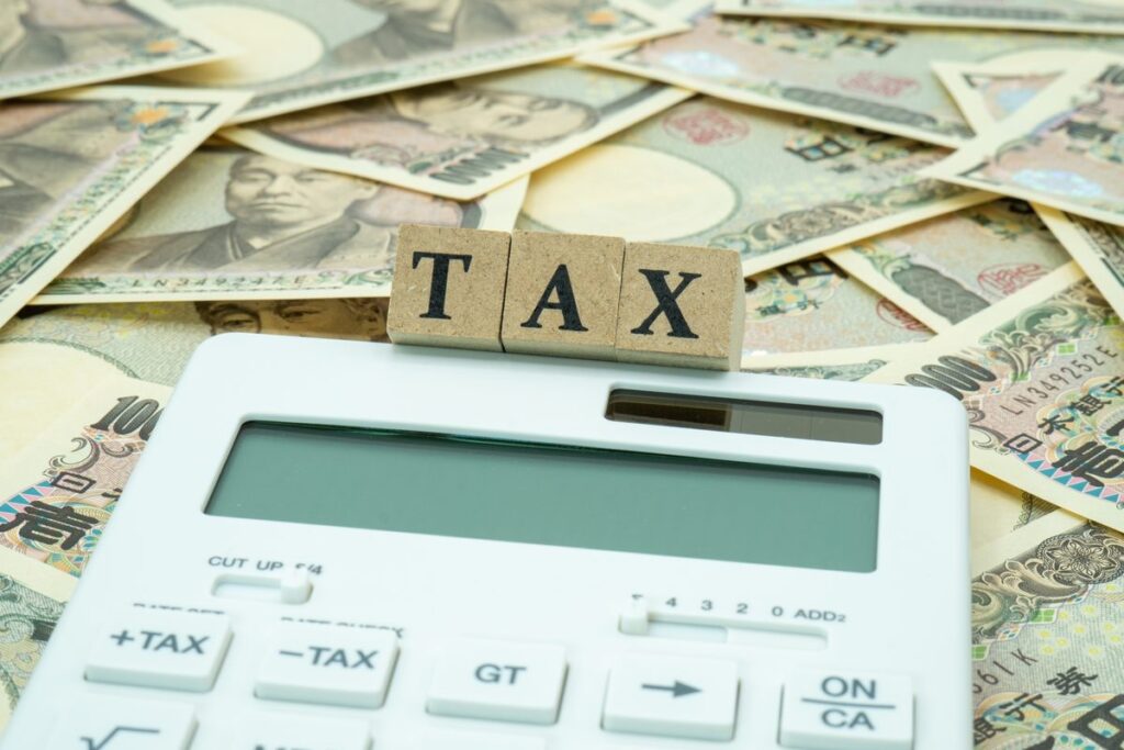 「TAX」の文字と電卓・紙幣