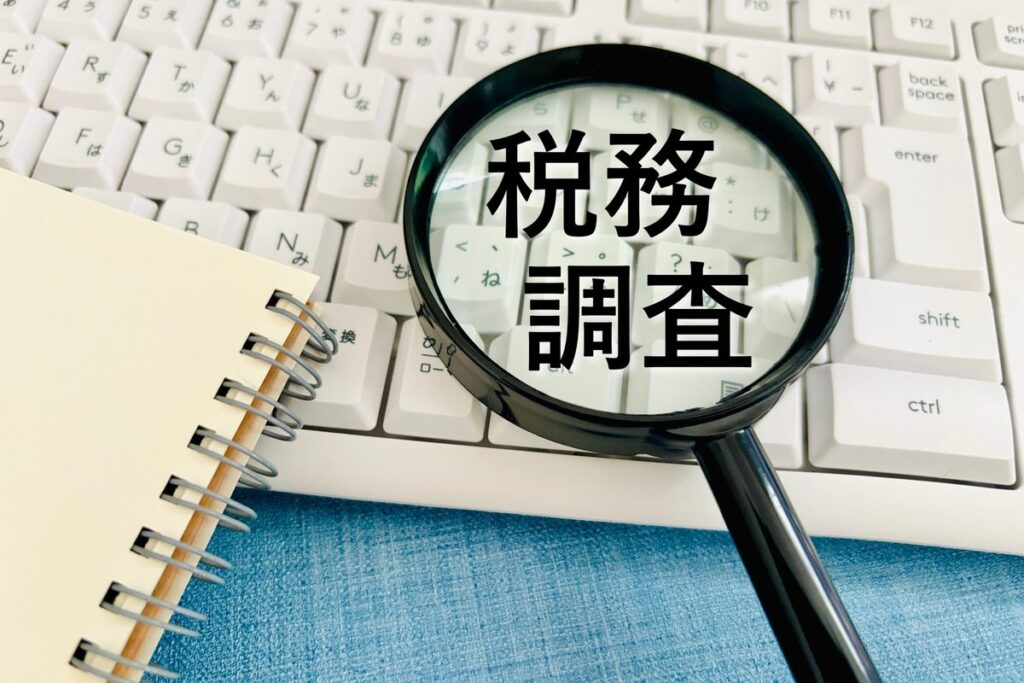 「税務調査」の文字と虫眼鏡・キーボード