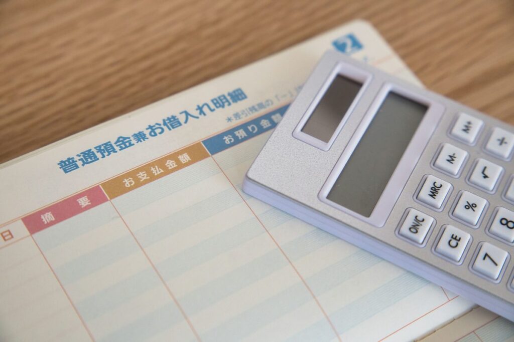 預金通帳の入出金明細と電卓