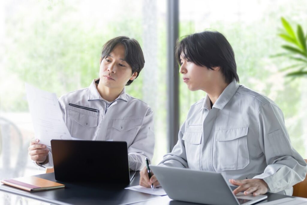 資料を見ながら話し合う社員