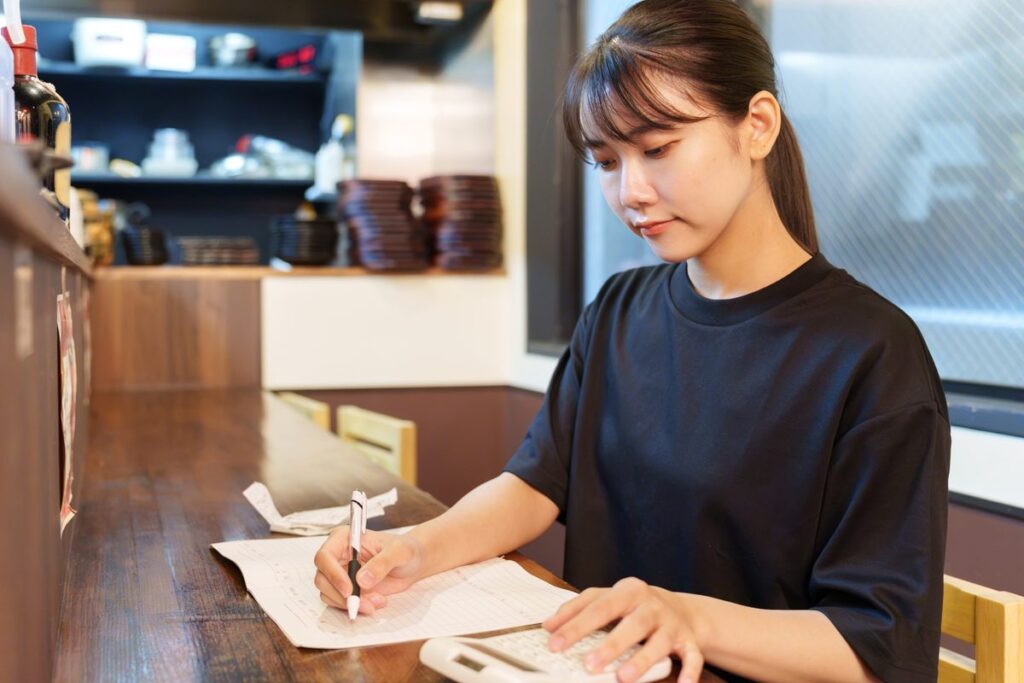 帳簿に記帳している経理担当者