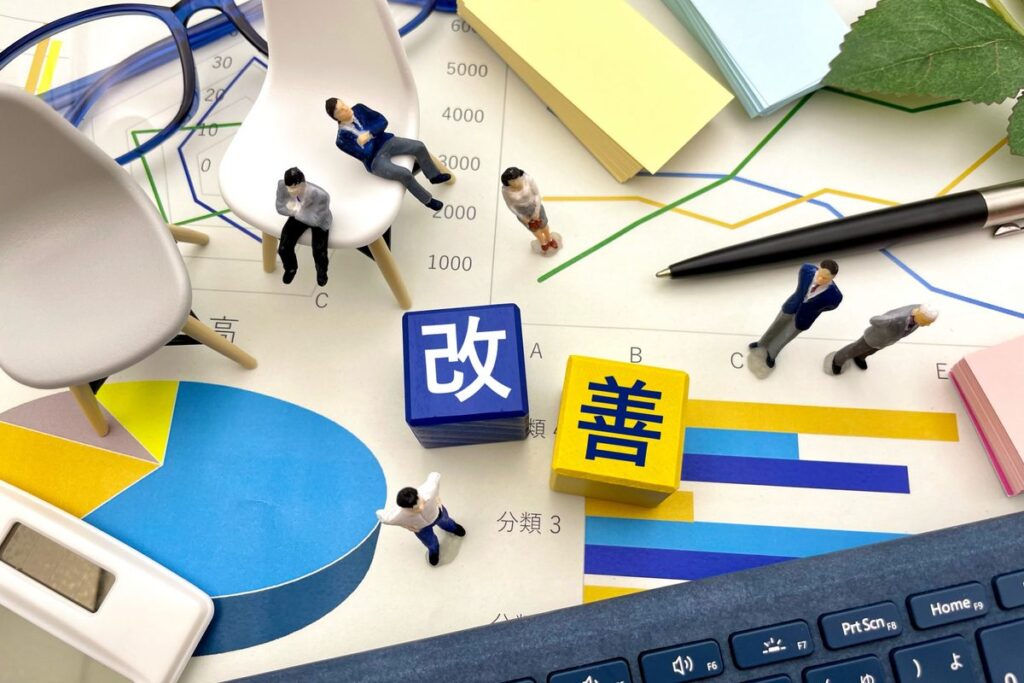 「改善」の文字と人形・資料