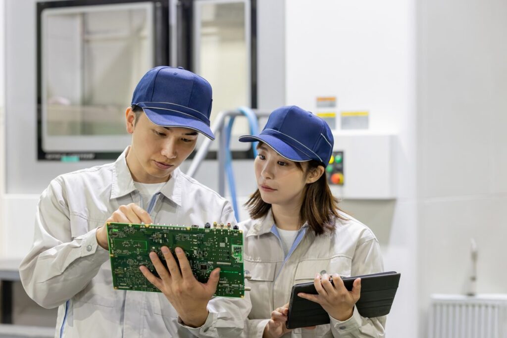 工場で基板を確認する作業員