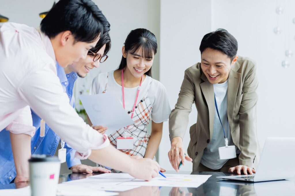 資料を囲んで話し合う会社員