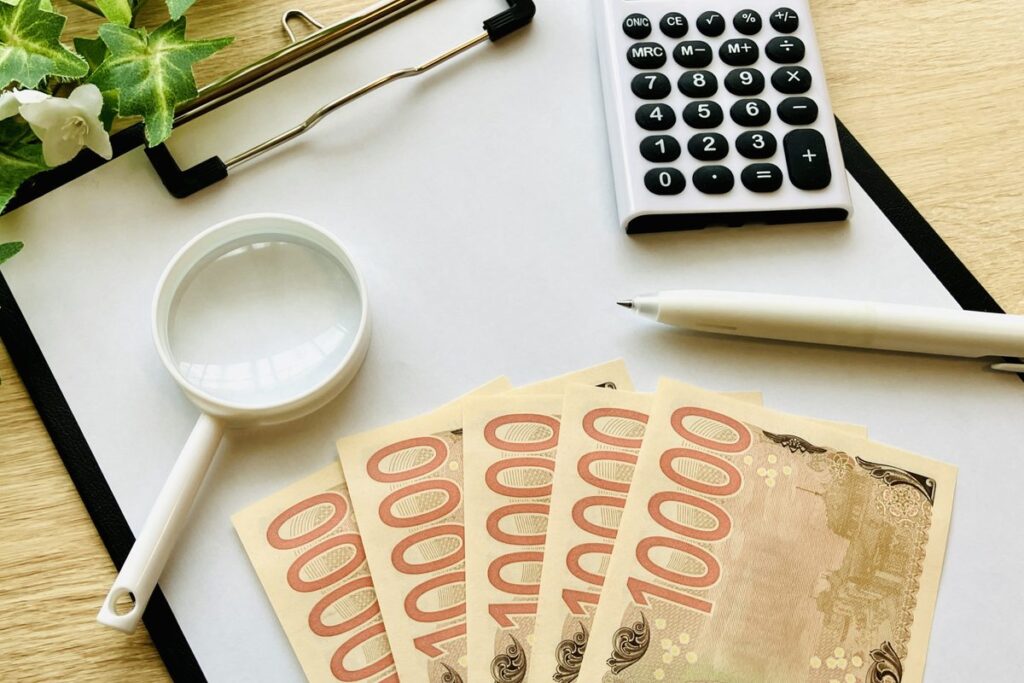 紙幣と電卓で税金を計算するイメージ