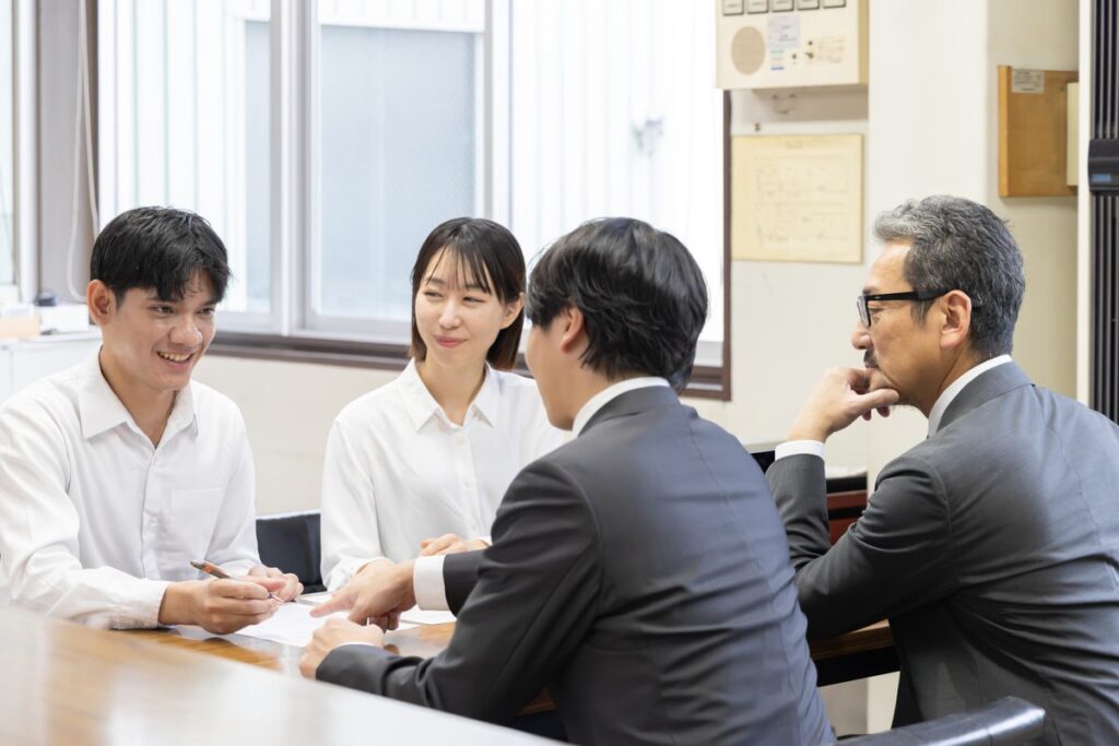 会議室で打ち合わせをする会社員
