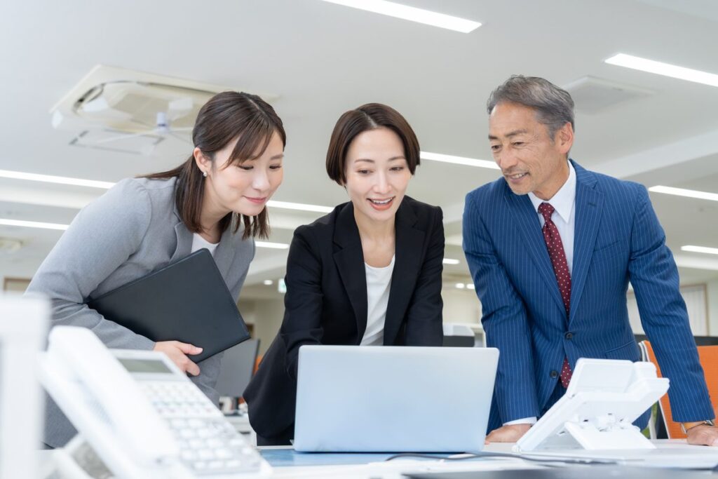 パソコンを見ながら打ち合わせをする会社員