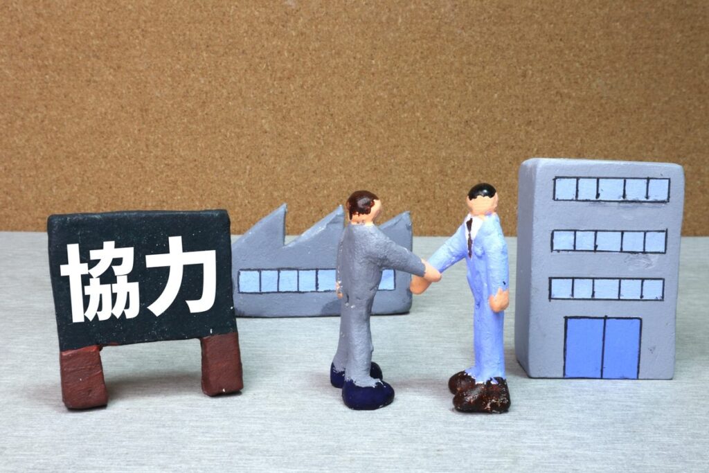 「協力」の看板と工場・ビルの模型