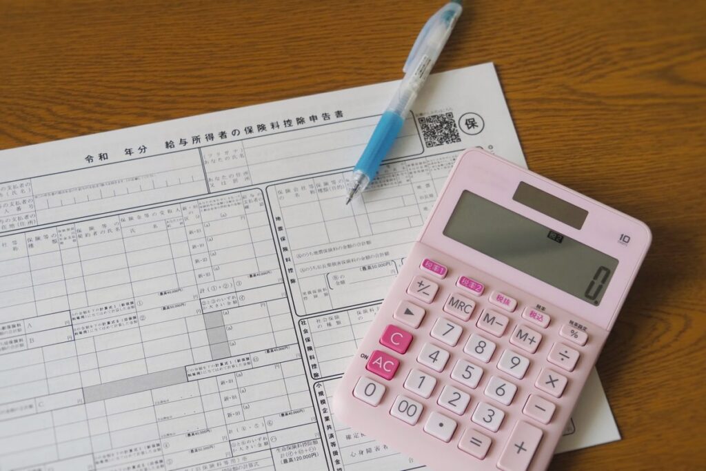 書類と電卓で年税額を計算するイメージ