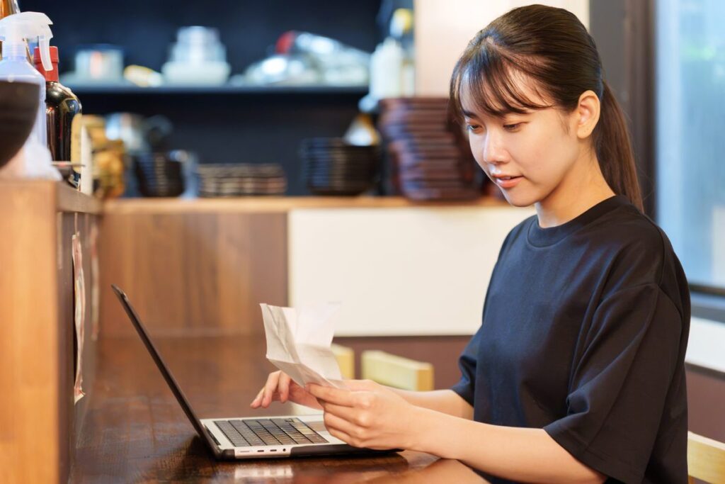パソコンで給与データを照合する経理担当者