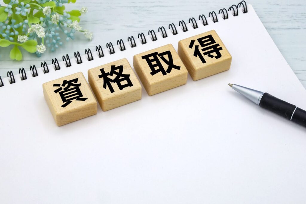 「資格取得」と書かれた積み木とノート