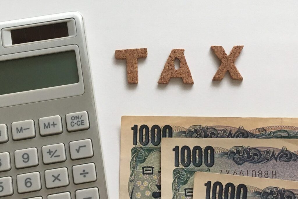 「TAX」の文字と電卓・紙幣