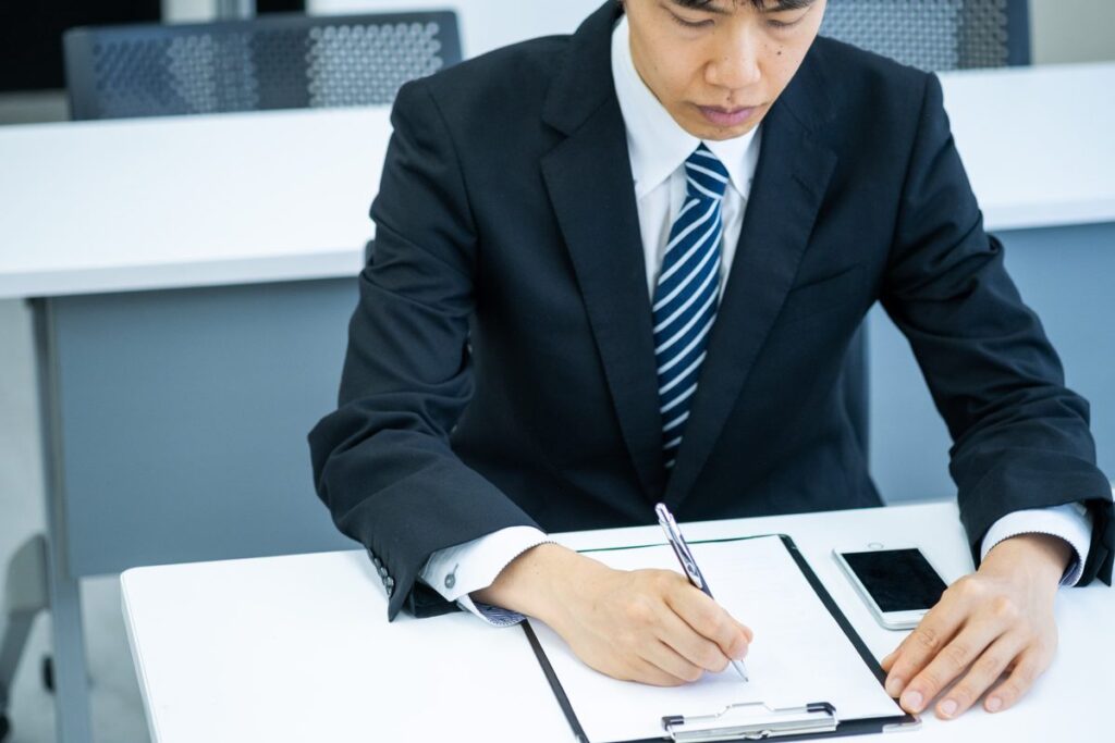 書類に署名するビジネスパーソン