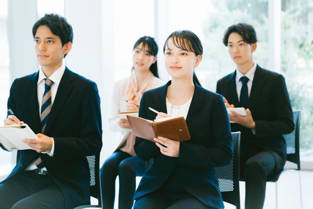 セミナーでメモを取りながら学ぶ会社員