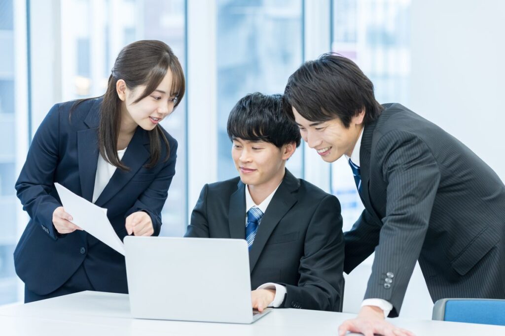 ノートパソコンを囲んで打ち合わせる3人