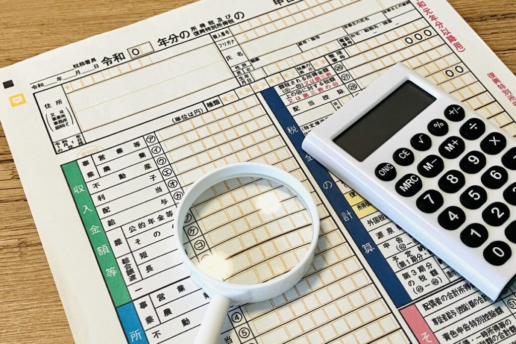 申告書と電卓・虫眼鏡で数字を確認するイメージ