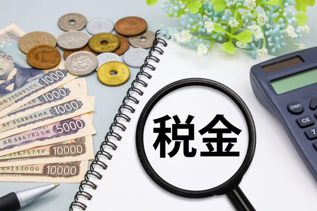 「税金」の文字と虫眼鏡・紙幣