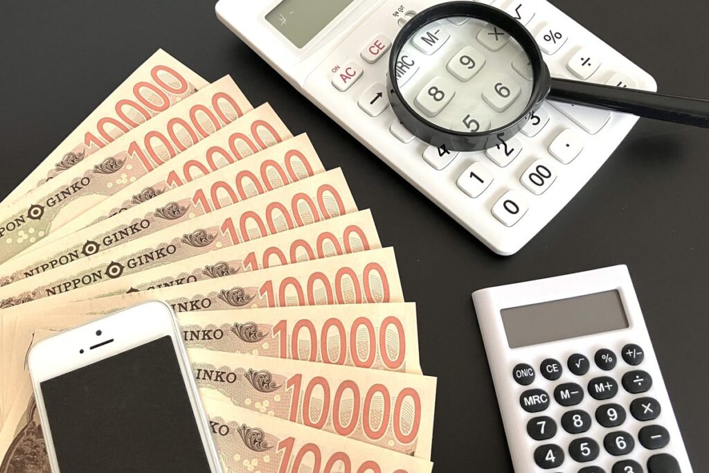 電卓と虫眼鏡で金額を確認する様子