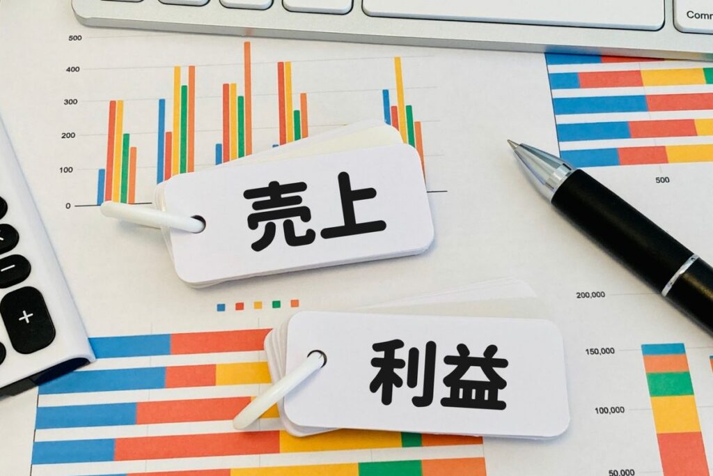 「売上」「利益」の札とグラフ資料