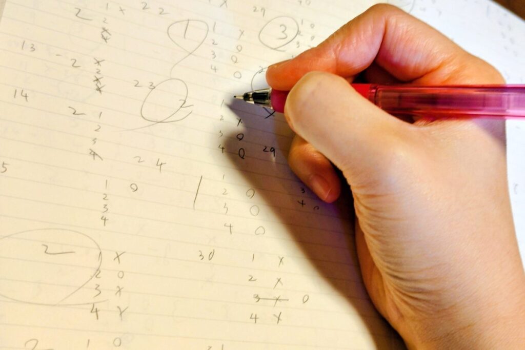 ノートに計算を書いて問題を解く様子