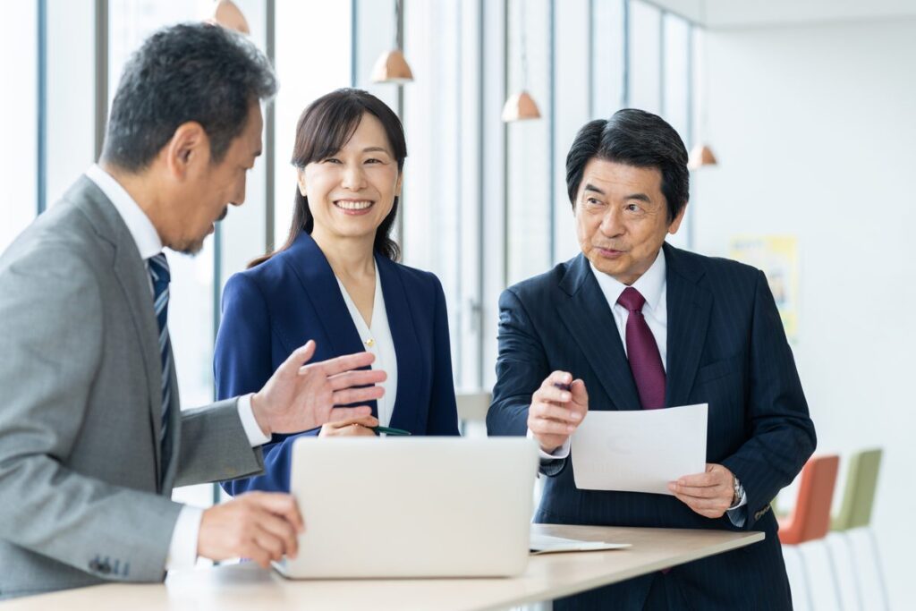 決算資料を見ながら打ち合わせをする社員たち